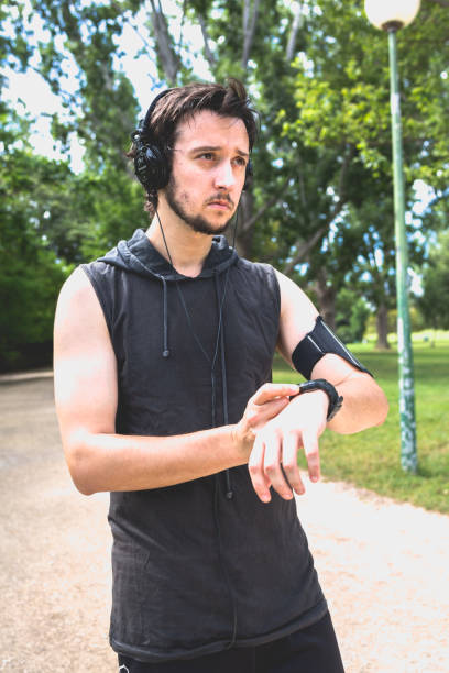 istock Runner Man Looks at his Smart Watch before Jogging 696856138