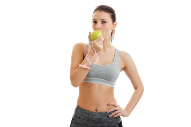 istock horizontal portrait slim girl who eats Green Apple 696856668