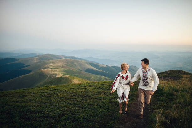 istock happy couple posing at mountains 696857078