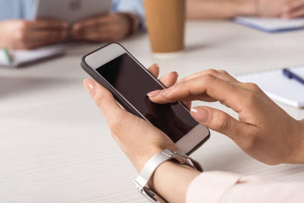 istock cropped shot of woman using smartphone with blank screen 696860788