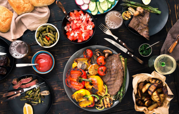 steak grillé avec des légumes grillés, bière et le vin sur une table en bois sombre, vue de dessus - horizontal steak dinner food photos et images de collection