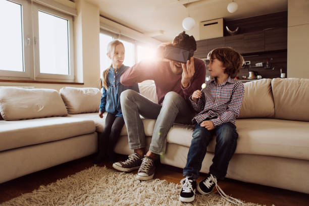 Father having a fun with his kids at home Father having a fun with his kids at home with VR glasses. head mounted display stock pictures, royalty-free photos & images