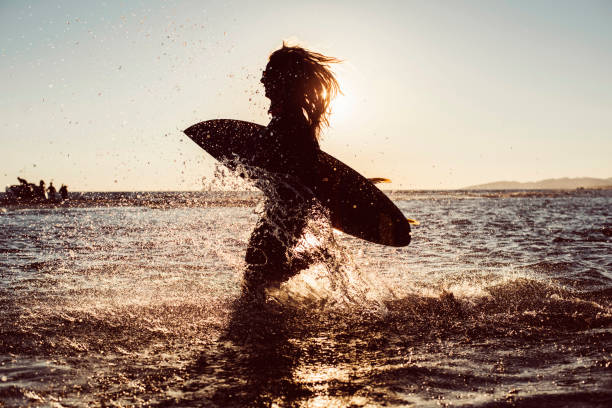 istock Female surfer silhouette running 696869670