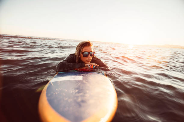 istock Female surfer floating on water 696869816