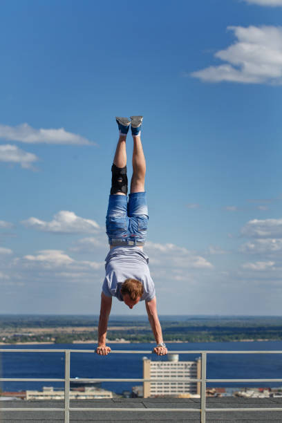 istock Roofer is standing upside down on edge of roof 696872724