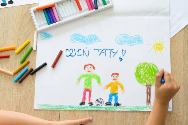 istock Happy child drawing father’s day card with Polish words 696873262