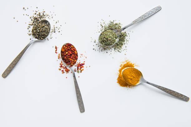 istock Top view of assorted aromatic spices in metal spoons isolated on white 696884178