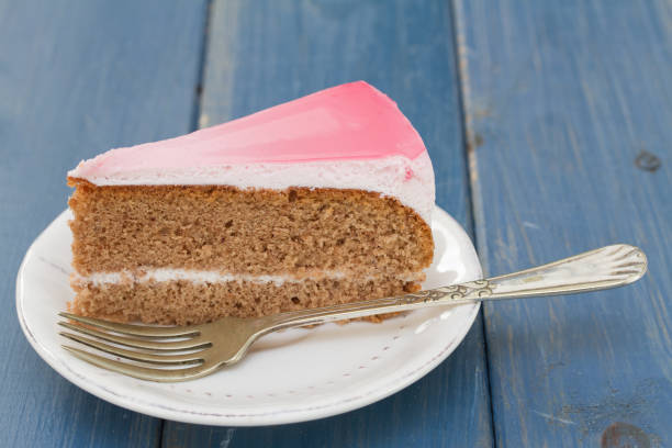 istock cake on white plate on blue wooden background 696885362