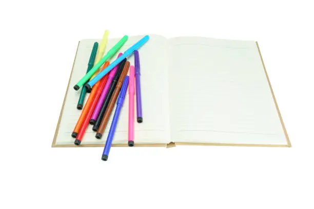 Photo of MultiColored Felt-Tip Pens or marker pens on notebook isolate on white background