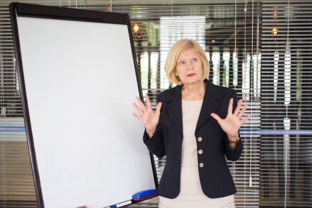 istock Pensive Senior Female Lecturer Explaining Idea 696885764