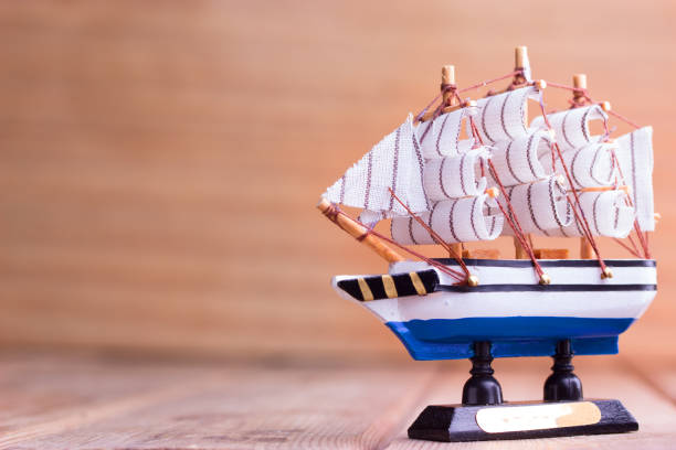 istock Toy sailboat on a wooden background 696886242