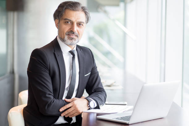 istock Confident senior man in suit working in cafe 696889784
