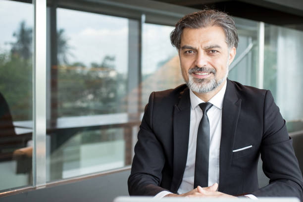istock Pleased handsome entrepreneur sitting at table 696889848