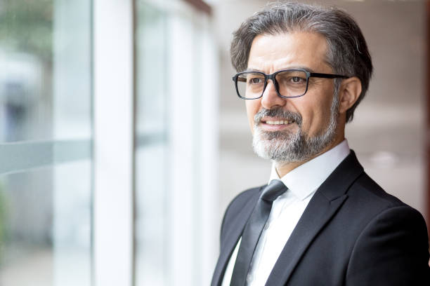 istock Pensive senior man in glasses looking out window 696889858