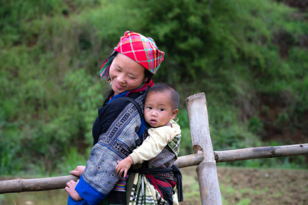 Mu Cang Chai, Yen Bai Province, Vietnam - May 20, 2017: Hmong ethnic woman carrying a child on her back