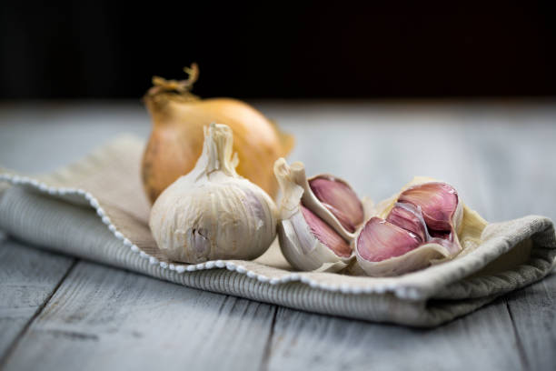Organic garlic and onion on wooden background Organic garlic and onion on wooden background with copy space garlic bulb photos stock pictures, royalty-free photos & images