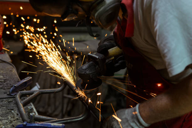istock Electric wheel grinding on steel structure in a workshop. 696898020