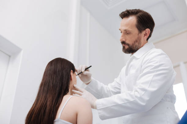 istock Tender admirable beautician using pencil for marking important areas 696898038