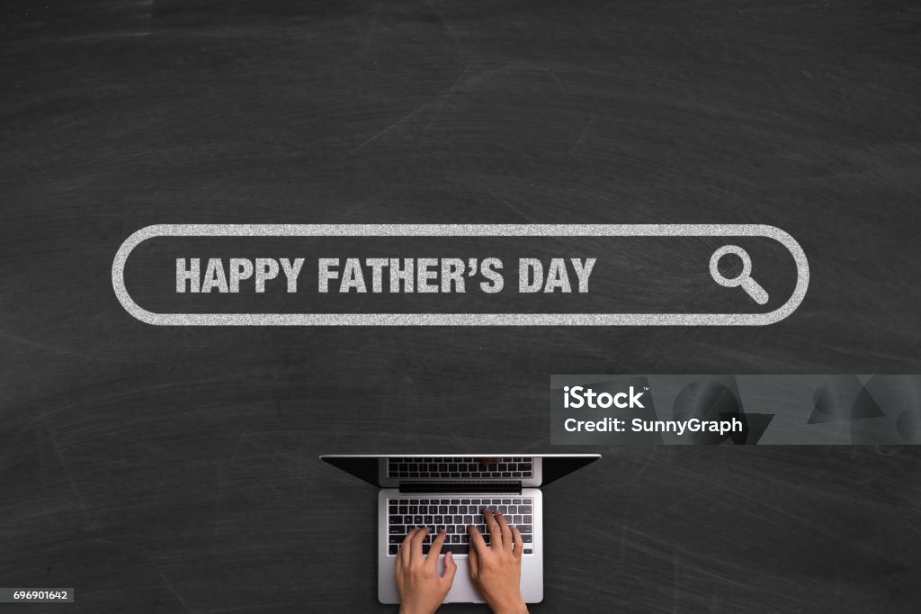 Happy Fathers Day Concept With Laptop On Blackboard Happy Fathers Day concept with hands typing laptop on the blackboard background. Computer Stock Photo