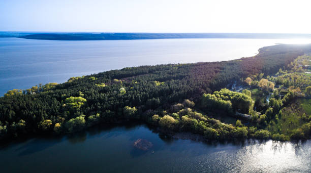 istock Aerial: Flying over a lake with sun illuminating the water. 696902016