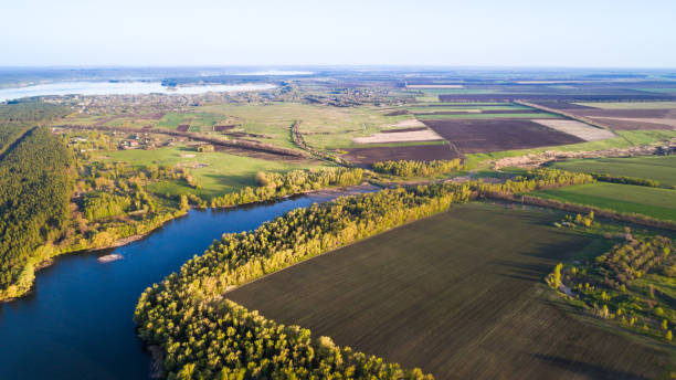 istock Aerial: Flying over a lake with sun illuminating the water. 696905042