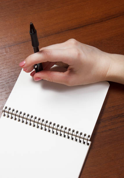 istock woman hands holding pen down up . Top View with Copy Space 696905130