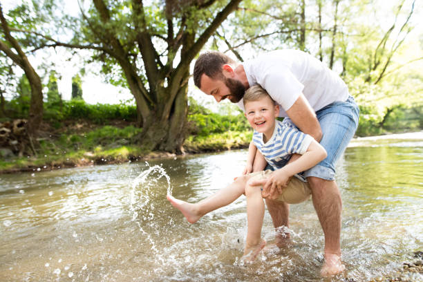 istock Young father with little boy in the river, sunny spring day. 696916322
