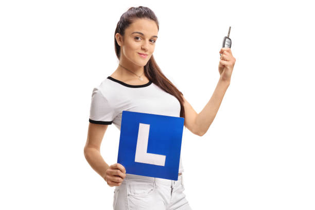 chica adolescente sosteniendo una llave de coche y una señal de l - l plate fotografías e imágenes de stock