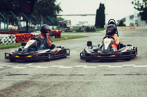 Mother and father go-Karts together. Driving from start position on driveway