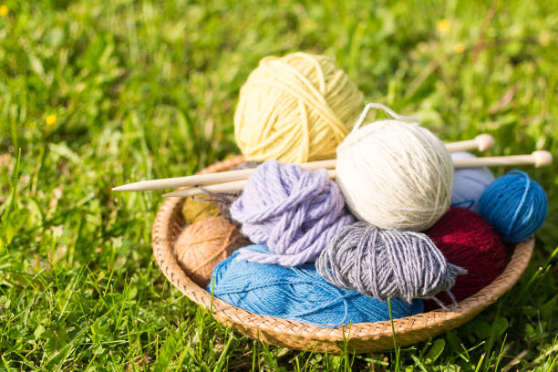 istock Set of colored yarn balls and needles on straw plate 696920812