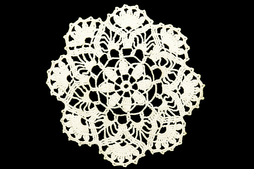 Lace doily. Black background, not isolated.