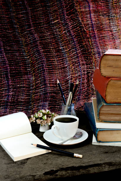 istock Old books coffee  cup, compass and pencil on a wooden. 696921754