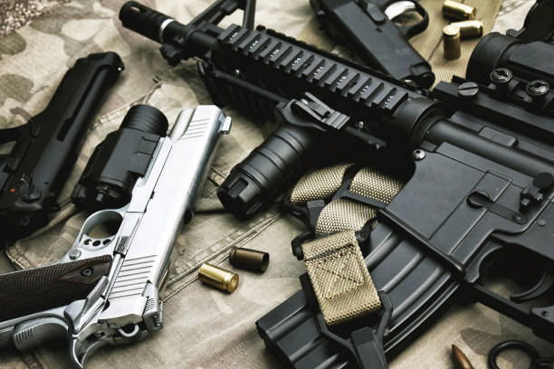 armas y equipo militar para el ejército, cañón de rifle de asalto (m4a1) y pistola sobre fondo de camuflaje. - arma de mano fotografías e imágenes de stock