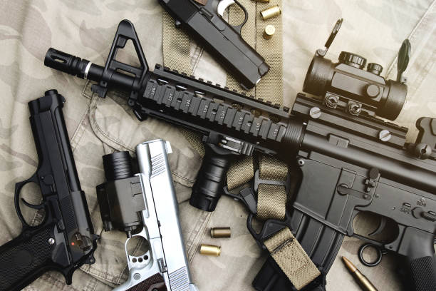 armas y equipo militar para el ejército, cañón de rifle de asalto (m4a1) y pistola sobre fondo de camuflaje. - gun weapon military m16 fotografías e imágenes de stock