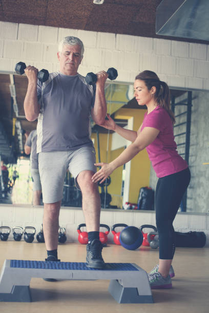 istock Personal trainer working exercise with senior man. Workout in gym. 696931492