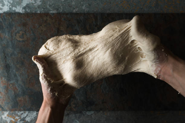 Dough for bread in the hands top view stock photo