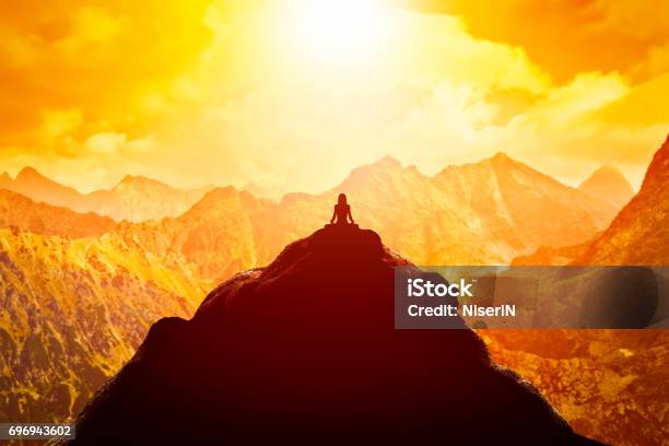 Woman Meditating In Sitting Yoga Position On The Top Of A Mountains Above Clouds At Sunset Stock Photo - Download Image Now