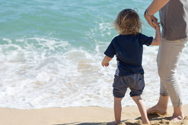 istock Mother and son having fun on the beach 696947098