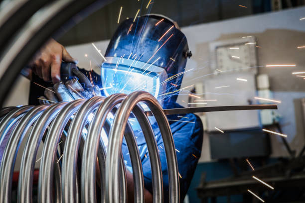 Worker is welding metal tubes. Details of the production process. metalwork stock pictures, royalty-free photos & images