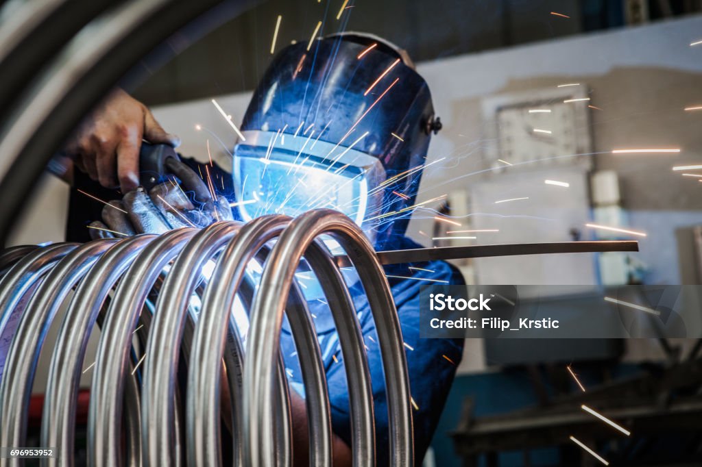 Trabalhador é soldagem de tubos de metal. - Foto de stock de Metal royalty-free