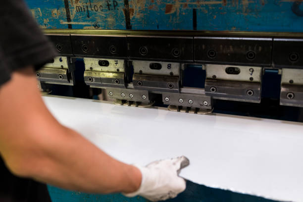 istock Worker bending a sheet of aluminium. 696954730