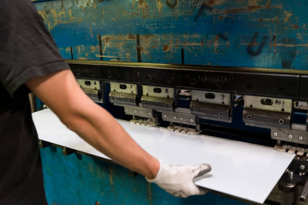 istock Worker bending a sheet of aluminium. 696954732