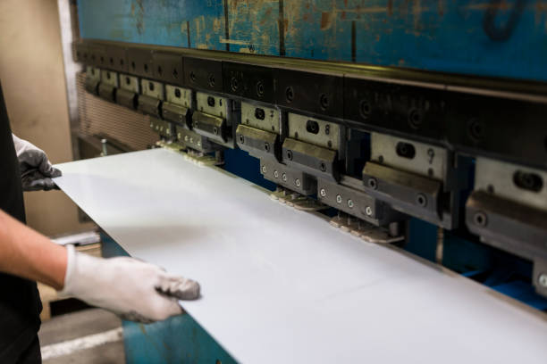 Worker bending a sheet of aluminium. stock photo