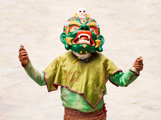 Unidentified monk with ritual bell and vajra performs a religious masked and costumed mystery dance of Tibetan Buddhism during the Cham Dance Festival stock photo