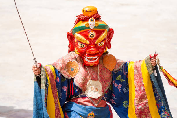 Unidentified monk with ritual sword performs a religious masked and costumed mystery dance of Tibetan Buddhism during the Cham Dance Festival Hemis, India - June 29: unidentified monk with ritual sword performs a religious masked and costumed mystery dance of Tibetan Buddhism during the Cham Dance Festival on June 29, 2012 in Hemis monastery, India. cham mask stock pictures, royalty-free photos & images