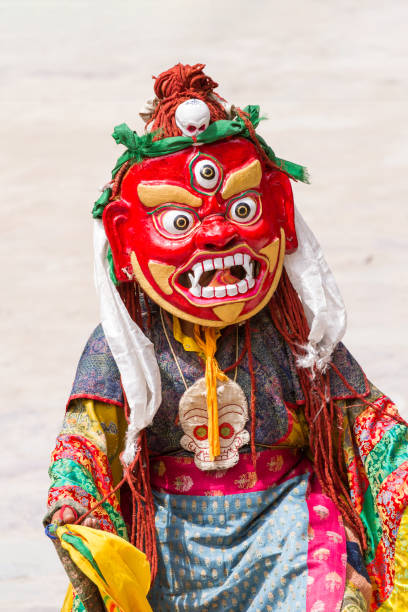 Unidentified monk in ritual mask performs a religious masked and costumed mystery dance of Tibetan Buddhism during the Cham Dance Festival Hemis, India - June 29: unidentified monk in ritual mask performs a religious masked and costumed mystery dance of Tibetan Buddhism during the Cham Dance Festival in Hemis monastery, India. cham mask stock pictures, royalty-free photos & images