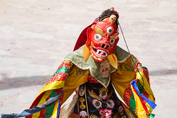 Unidentified monk in ritual mask performs a religious masked and costumed mystery dance of Tibetan Buddhism during the Cham Dance Festival Hemis, India - June 29: unidentified monk in ritual mask performs a religious masked and costumed mystery dance of Tibetan Buddhism during the Cham Dance Festival in Hemis monastery, India. cham mask stock pictures, royalty-free photos & images