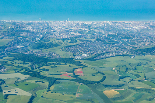 A photograph taken from an airplane in early summer, of the Brighton coastline and South Downs.