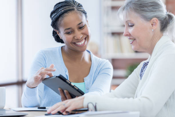 istock Female financial advisor counsels senior client 696977636