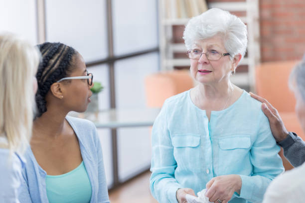 istock Emotional senior woman during group therapy session 696977690